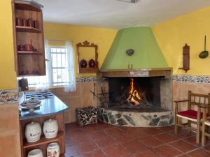 a kitchen with a fireplace with a green roof at Casa Rural Angorrilla in Reolid