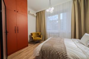 een slaapkamer met een bed, een stoel en een raam bij Złota 7 Apartment in Warschau