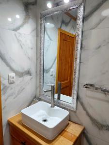 a bathroom with a sink and a mirror at Cabañas Lagos y Volcanes in Coñaripe +23 photos