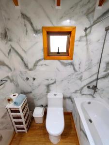 une salle de bain avec toilettes, lavabo et baignoire dans l'établissement Cabañas Lagos y Volcanes, à Coñaripe