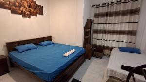 a bedroom with a bed with blue sheets and a window at Kandy Jungle Border in Kandy +32 photos