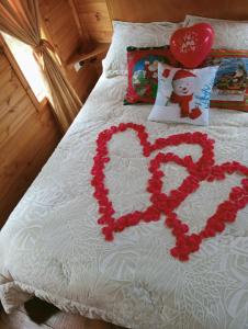 a heart made out of flowers on a bed at Cabaña Los Linos in Guasca