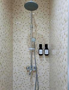 a shower with two bottles of soap on the wall at Feel Porto in Bolhão "Metro at your doorstep" in Porto +36 photos