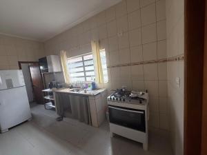 a kitchen with a stove and a sink and a refrigerator at Chácara Ana Clara in Cotia