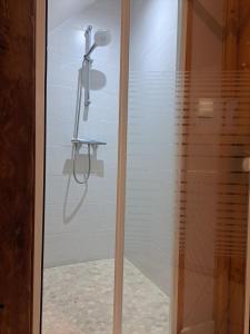 a shower with a glass door in a bathroom at La Petite Longère in Talcy