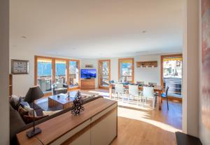 a living room with a couch and a table at Chalet Waldschluecht in Wengen