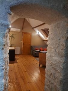 een woonkamer met een stenen muur en een bank bij La Petite Longère in Talcy +13 foto's