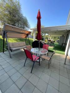 eine Terrasse mit Tisch, Stühlen und Sonnenschirm in der Unterkunft Grill Patio • Pet Friendly / 3 BR in Charlotte