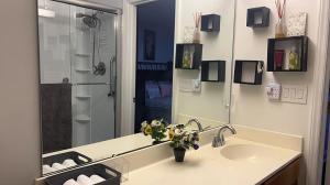 ein Badezimmer mit Waschbecken und großem Spiegel in der Unterkunft Grill Patio • Pet Friendly / 3 BR in Charlotte