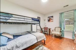 ein Schlafzimmer mit einem Etagenbett und einem Stuhl in der Unterkunft Grill Patio • Pet Friendly / 3 BR in Charlotte