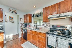 eine Küche mit Holzschränken und einem Herd mit Backofen in der Unterkunft Grill Patio • Pet Friendly / 3 BR in Charlotte + 10 Fotos