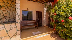 een veranda met een bank en wat bloemen bij Casa com Jacuzzi, Piscina e Garagem em Jacuipe in Barra de Jacuípe