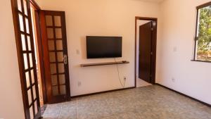 een kamer met een flatscreen-tv aan de muur bij Casa com Jacuzzi, Piscina e Garagem em Jacuipe in Barra de Jacuípe