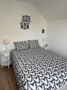 een slaapkamer met een zwart-wit bed en 2 lampen bij Résidence de l'Authie in Groffliers +2 foto's