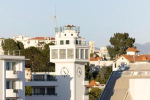 un edificio bianco con una torre dell'orologio in una città di Crisol Promenade a Nizza Altre 30 foto