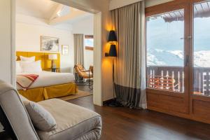 a hotel room with a bed and a balcony at Le Val Thorens, a Beaumier hotel in Val Thorens