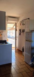 a kitchen with a refrigerator and a tile floor at Studio Emilie in Balaruc-les-Bains