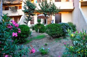 um jardim em frente a um edifício com flores em La Casetta Nella Baia em Santa Teresa Gallura