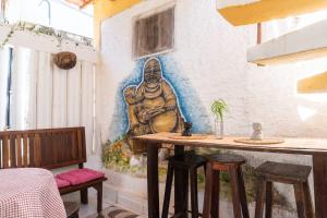 Een muurschildering in een restaurant met een tafel en krukken. bij Pousada Rose in Pipa