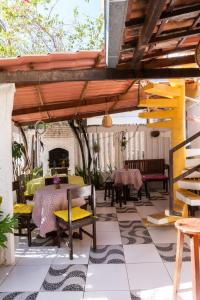 een terras met een tafel, stoelen en een open haard bij Pousada Rose in Pipa