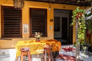 een tafel met twee krukken voor een huis bij Pousada Rose in Pipa +15 foto's