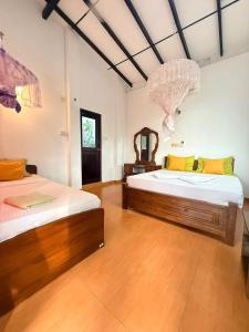 En eller flere senge i et værelse på Pearl Deluna Resort Mirissa