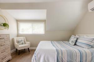a bedroom with a bed and a chair and a window at Boat House in Downingtown