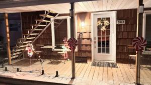 una casa con un portico con una scala e una porta di 564A Le Refuge Spa Riviere a Saint-Léon-de-Standon