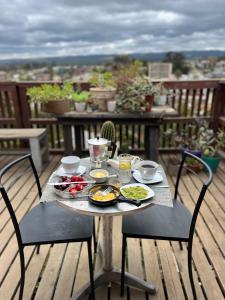 a table with plates of food on a balcony at Casa Mirador Pichilemu in Pichilemu