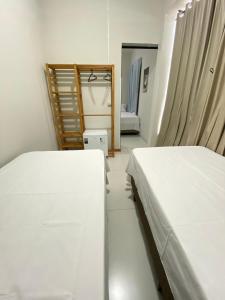 a bedroom with two beds and a mirror at Pousada Âncora in Gravataí