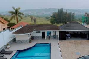 a house with a swimming pool in front of it at Dorlan Hotel in Kigali +12 photos