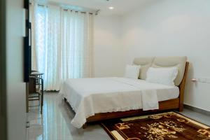 a white bedroom with a bed and a window at Dorlan Hotel in Kigali