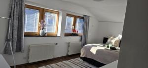 a bedroom with a bed and two windows at Central Apartment in Radstadt