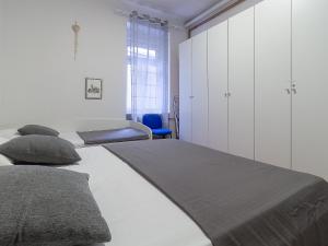 een slaapkamer met 2 bedden en een blauwe stoel bij Apartment G37 in Zagreb