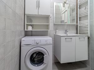 een witte wasruimte met een wasmachine en een wastafel bij Apartment G37 in Zagreb