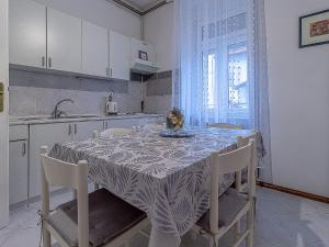een keuken met een tafel en stoelen met een tafel en een keuken bij Apartment G37 in Zagreb