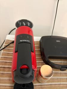 un telefono cellulare rosso e nero appoggiato accanto a un caricabatterie di Suíte Boqueirão Tati Ortega a Ilha Comprida Altre 32 foto