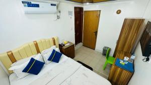 una camera da letto con un letto con cuscini blu e bianchi di Hotel Sweet Place a Gulshan 1 Altre 5 foto