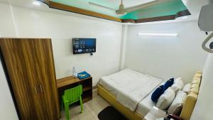 una piccola camera da letto con un letto e una TV di Hotel Sweet Place a Gulshan 1