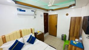una camera da letto con un letto con cuscini blu e bianchi di Hotel Sweet Place a Gulshan 1
