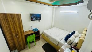 una piccola camera da letto con un letto e una televisione di Hotel Sweet Place a Gulshan 1