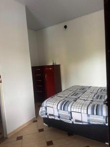 a bedroom with a bed and a red cabinet at Espaço Sol in Peruíbe +13 photos