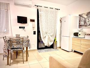 eine Küche mit einem Tisch und einem Kühlschrank in der Unterkunft Pine Beach House - Villaggio Turistico con Piscina e Animazione in Campofelice di Roccella + 47 Fotos