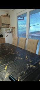 een keuken met een tafel en 2 stoelen en een koelkast bij D&M Apartman in Kruševo