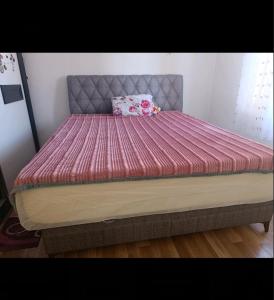 een bed met een roze dekbed erop bij D&M Apartman in Kruševo