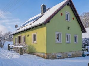 a small green and yellow house in the snow at Hohnstein in Hohnstein