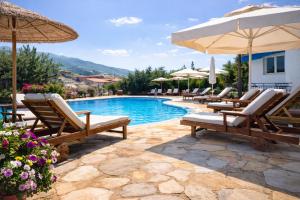 a swimming pool with lounge chairs and an umbrella at Villa Riviera in Stavros