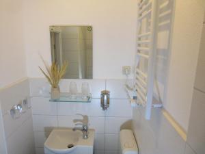 ein weißes Badezimmer mit Waschbecken und Spiegel in der Unterkunft Stadtzentrum , nähe Schloss in Klütz + 4 Fotos