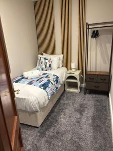 een kleine slaapkamer met een bed en een dressoir bij Vacant Nests Ivy Cottage 3BR Wi-Fi in Banton