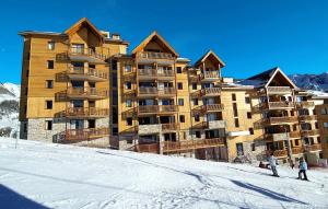 a large building on a ski slope in the snow at Résidence Odalys Rochebrune Le Vallon in Orcières
